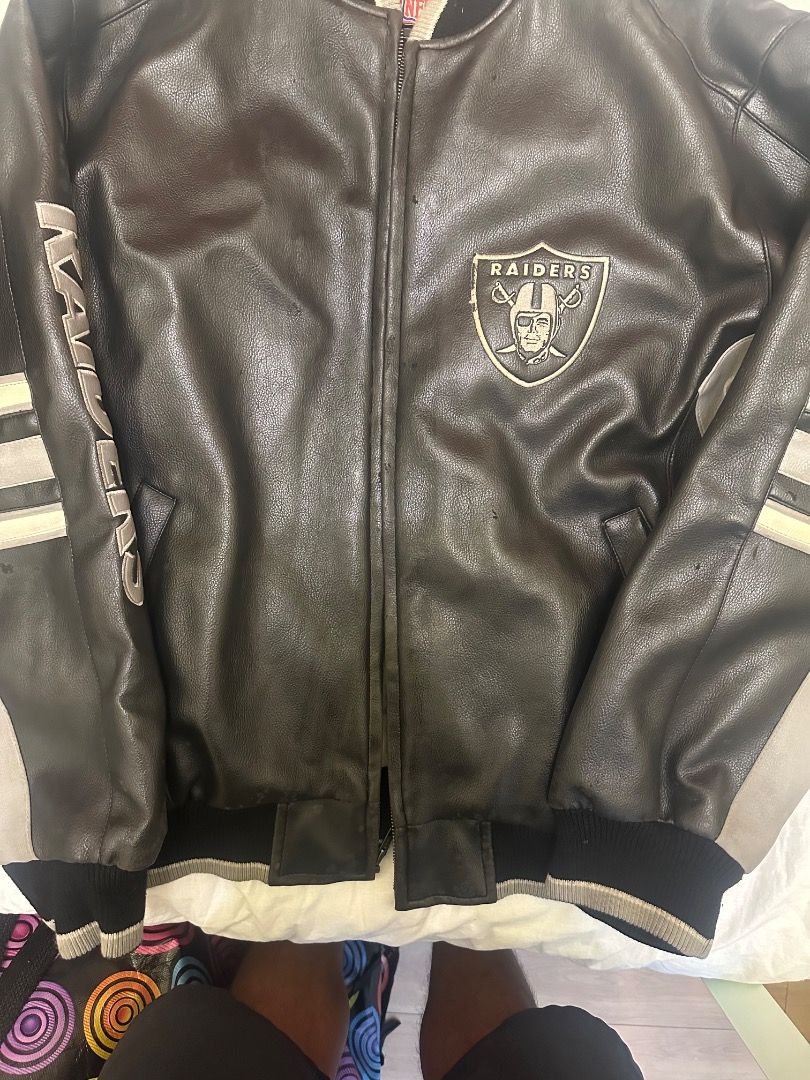 Las Vegas Raiders NFL Leather Bomber Jacket (Category: Coats, Jackets and Outerwear) located in Caloocan City. Submitted by tradermac (Listing ID 1470537537, Image 2). Description: - Authentic Las Vegas Raiders heavyweight leather jacket - Color: Classic black with grey and white striped detailing on sleeves - Features: Raiders logo patch on left chest and Raiders lettering down the right sleeve - Comfort: Ribbed collar, cuffs, and hem with front