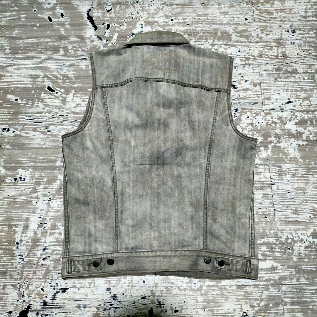 Levi's Acid Wash Denim Vest (Category: Vests) located in Zamboanga. Submitted by _oliverbmth (Listing ID 1470523765, Image 2). Description: - Brand: Levi's - Color/Wash: Grey acid wash - Closure: Button-up front with metallic hardware - Pockets: Dual chest pockets and two front welt pockets - Details: Classic collar, signature red tab on left pocket, intact neck label - Style: Rugged, sturdy denim construction - Dimes 21x27.