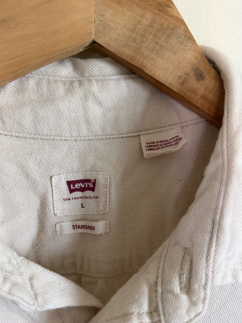 Levi's Standard Fit Off-White Button-Down Shirt Size L (Category: Formal Shirts) located in Manila. Submitted by snipe.shit (Listing ID 1470424710, Image 3). Description: - Brand: Levi's - Style: Long sleeve button-down shirt - Color: Off-white - Size: Large - Material: Solid cotton-blend twill - Details: Dual chest pockets, signature red tab logo, standard collar, button cuffs - Condition: Excellent, well-maintained - Shipping: Ships out via J&T
