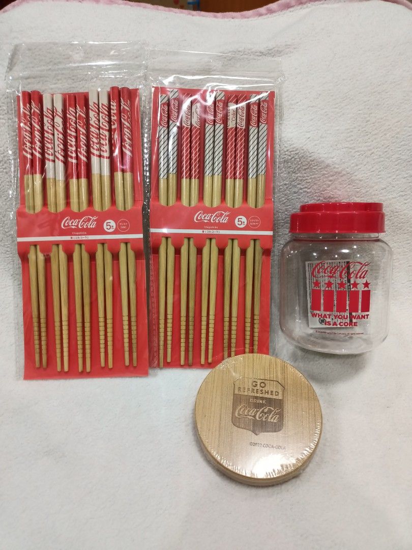 Licensed Coca-Cola Chopsticks Plastic Storage Jar Coaster Merchandise Bundle Set (Category: Food Organization & Storage) located in Manila. Submitted by jollynest24 (Listing ID 1470504579, Image 1). Description: - Official 2022 Coca-Cola Collector's bundle - 2x packs of wooden chopsticks (5 pairs per pack, unopened) - 1x clear plastic storage jar with red Coca-Cola logo, 'What You Want Is A Coke' text, and red lid - 1x round wooden coaster stampe