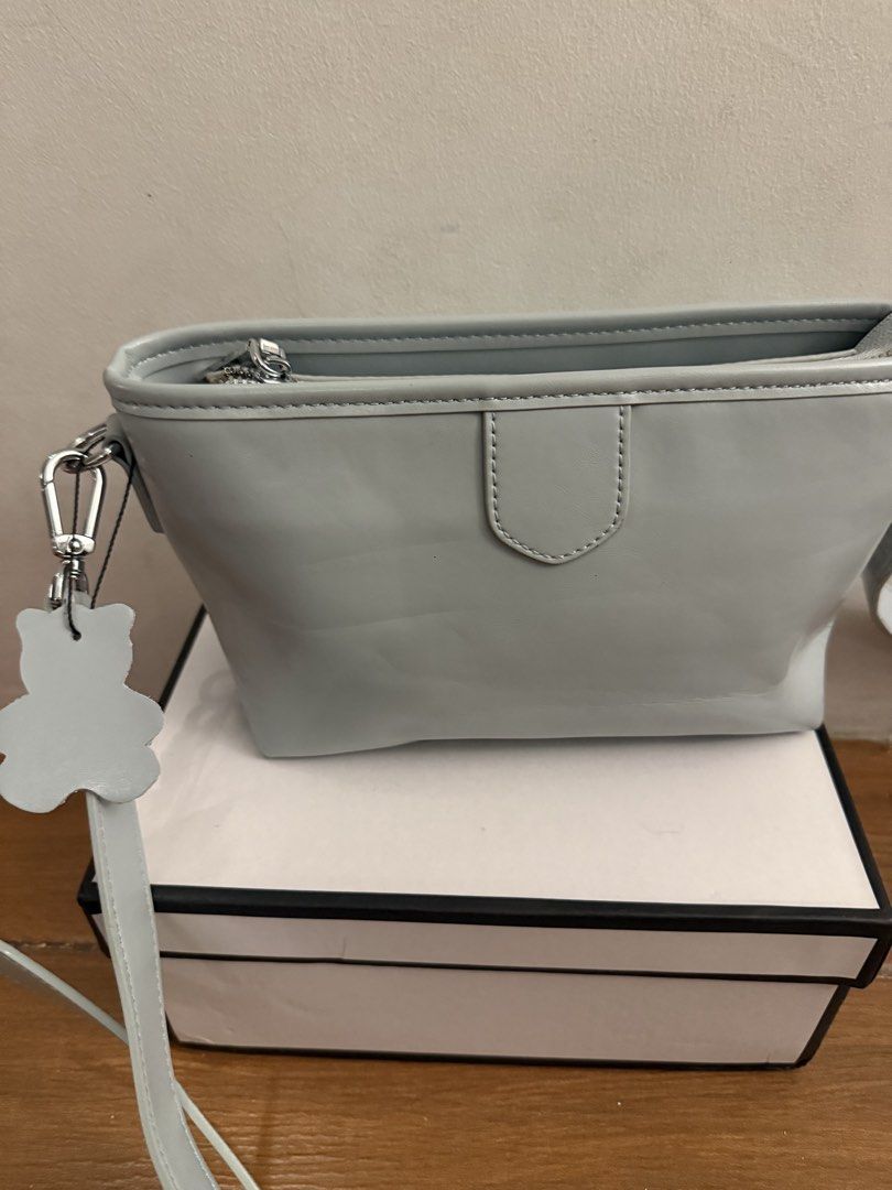 Light blue cross-body handbag with bear tag (Category: Cross-body Bags) located in Bulacan. Submitted by emjay_17 (Listing ID 1470452289, Image 3). Description: - Color: Light blue - Material: Sleek leather-like texture - Closure: Secure top zipper with clean interior lining - Strap: Includes matching adjustable shoulder strap - Extras: Cute bear-shaped charm included - Condition: Kept in shape with original stuffing inside - Packaging: Box inclu