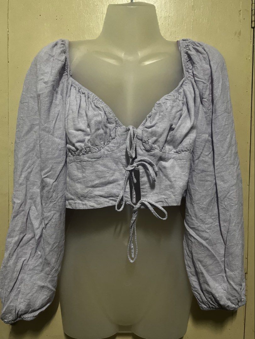 Light Purple Ruched Crop Top with Long Sleeves (Category: Longsleeves) located in Tabuk. Submitted by zenwolf-1867 (Listing ID 1470532172, Image 2). Description: - Color: Light purple with a subtle pattern - Neckline: Sweetheart neckline with chic bust ruching - Closure: Cute tie closure down the center front - Sleeves: Long sleeves with gathered shoulders and elastic cuffs - Fit: Cropped length that hits right at the waist - Feel: Made from a so