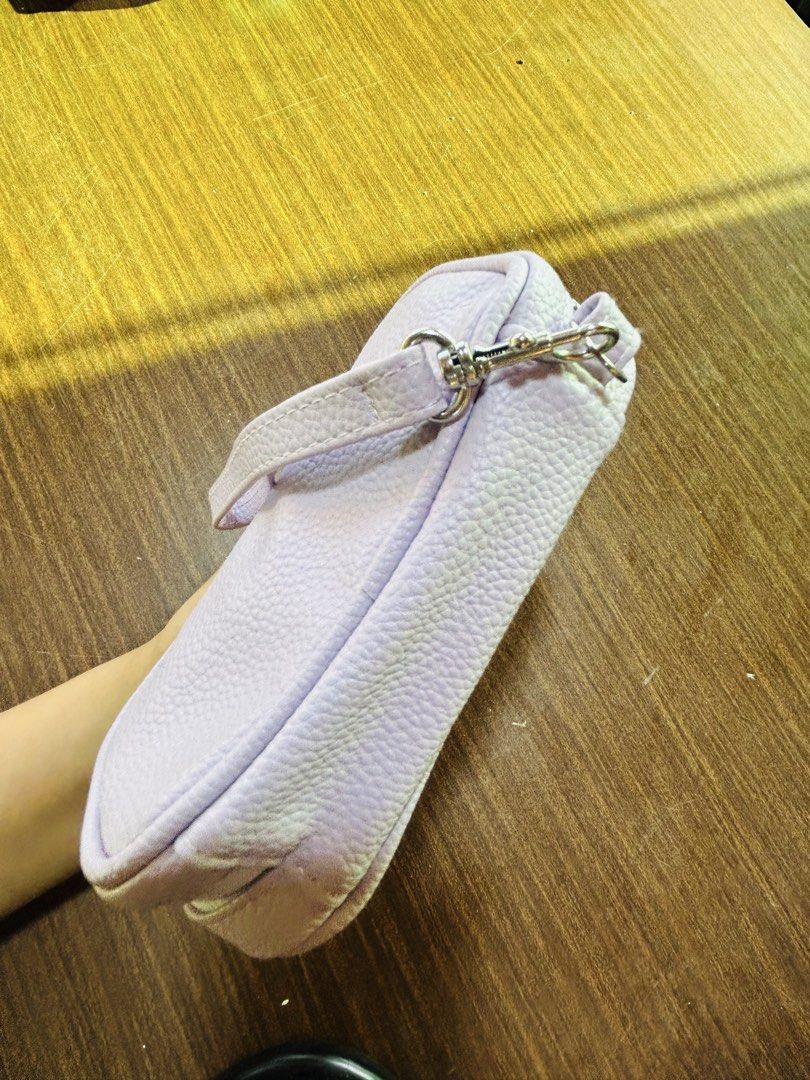 Light Purple Textured Pouch With Wrist Strap (Category: Purses & Pouches) located in Manila. Submitted by starbalesukandjapansurplus (Listing ID 1470555421, Image 2). Description: - Color: Light purple pebbled faux leather - Hardware: Silver-tone zipper closure - Strap: Removable wrist strap for versatile carrying - Interior: White lining with built-in mesh compartments for easy organization - Size: Compact and handy, perfect for daily essentials