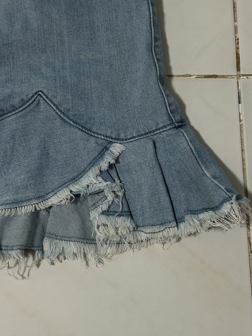 Light Wash Denim Ruffle Skirt (Category: Skirts) located in Manila. Submitted by viyyu (Listing ID 1470413407, Image 2). Description: •Mini skirt with fun ruffled hem and raw frayed edges •Mid-rise with standard sizing •Front zip fly, button closure, and belt loops •Functional pockets on both front and back.
