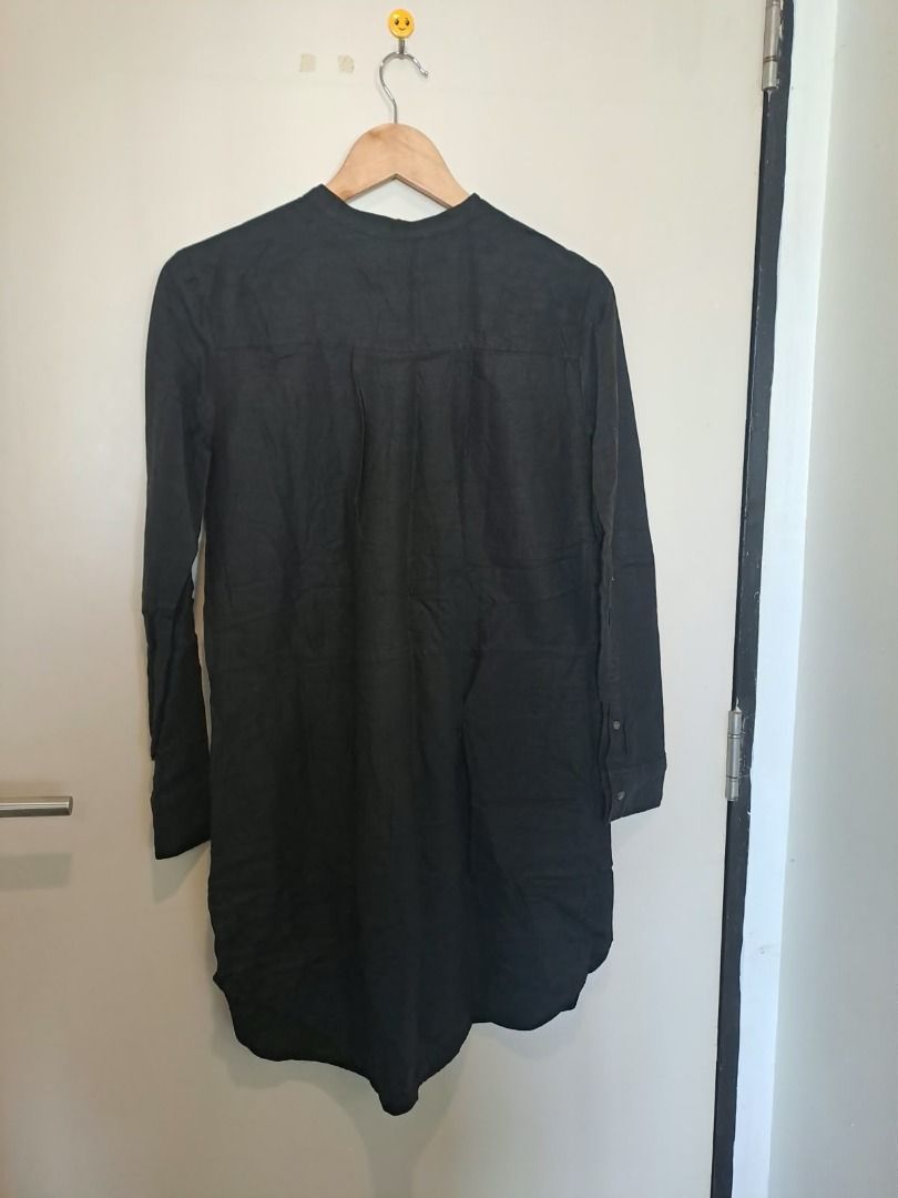 Linen tunic dress black (Category: Dresses) located in Mandaluyong City. Submitted by epicowl-c93c (Listing ID 1470385701, Image 3). Description: This garment is a black long-sleeve linen tunic dress featuring a classic band (or grandad) collar and a clean, button-down placket hidden down the front center line. Its minimalist aesthetic, relaxed silhouette, and lightweight, naturally textured linen weave make it an exceptionally versatile wardrobe
