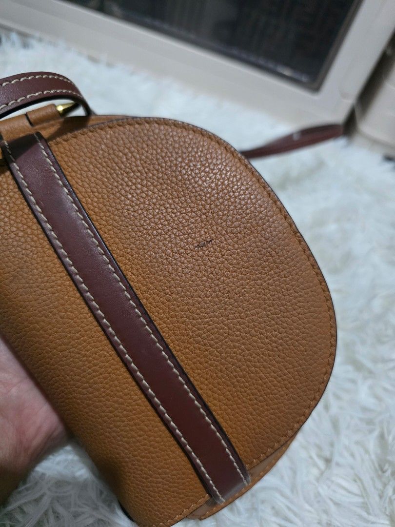 Loewe Gate Small Leather Crossbody Bag Tan (Category: Cross-body Bags) located in Lemery. Submitted by venus23 (Listing ID 1470512323, Image 3). Description: - Material: Tan pebble grain leather with structured saddle shape - Accents: Contrasting dark brown strap detail, front flap knot closure, and gold-tone hardware - Branding & Finish: Embossed logo on top left flap with black edge glazing - Strap: Adjustable thin shoulder strap - Condition: S