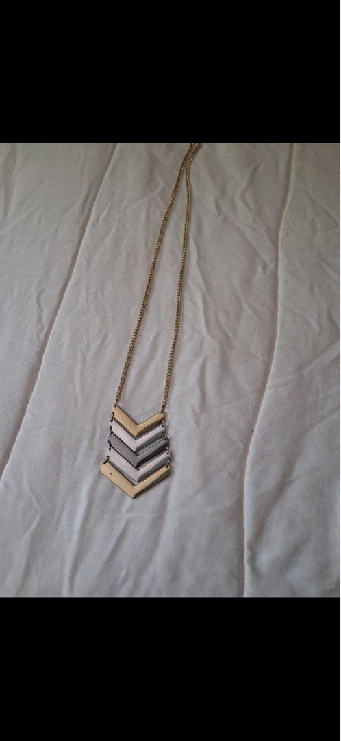 Long chain necklace with multi-tone chevron pendant (Category: Necklaces) located in Muntinlupa City. Submitted by everythingmustgo_8475da (Listing ID 1470485006, Image 1). Description: - Style: Long gold chain necklace with a stacked chevron pendant - Colors: Alternating layers of gold, silver, and grey tones - Features: Lightweight and easy to wear - Perfect for: Elevating plain tops or dresses.
