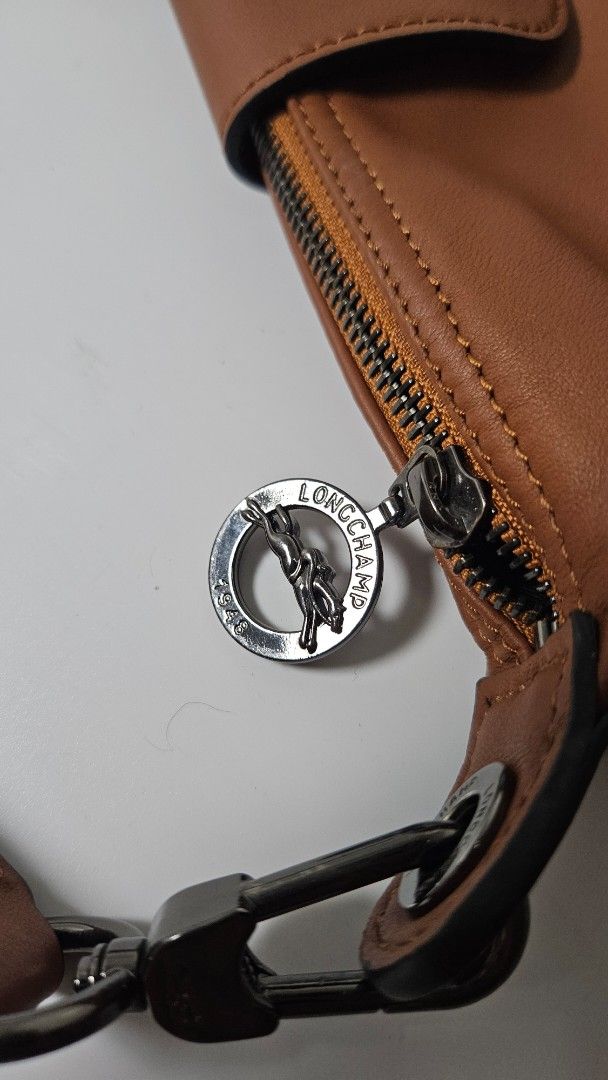 Longchamp Le Pliage Xtra Bag (Category: Luxury Bags & Wallets) located in Alfonso. Submitted by jbcamet (Listing ID 1470400615, Image 3). Description: - Brand: Longchamp - Material: Premium brown leather in rich tan with contrast stitching - Closure: Top zip closure with front flap pocket - Hardware: Silver-tone with iconic horse logo embossed on snap and zipper pulls - Strap: Adjustable strap with metal clips on both sides - Interior: Spacious m