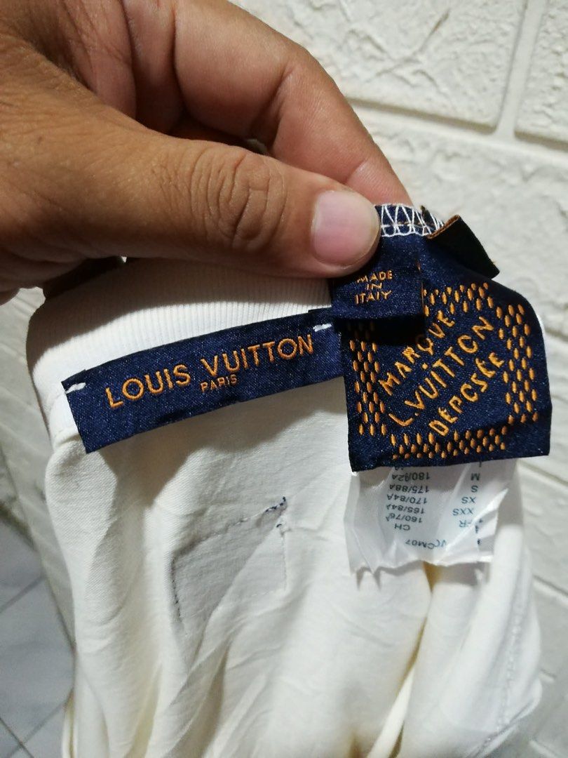 Louis Vuitton Lovers White T-Shirt (Category: Formal Shirts) located in Rizal. Submitted by tiangarcia02 (Listing ID 1470521108, Image 2). Description: - Authentic Louis Vuitton short-sleeve t-shirt in classic white - Features textured 'Lovers' front graphic with monogram diamond accent - Comfortable crew neck design made from soft, breathable cotton - Made in Italy with original blue collar, size, and care tags intact - Clean overall appearance 