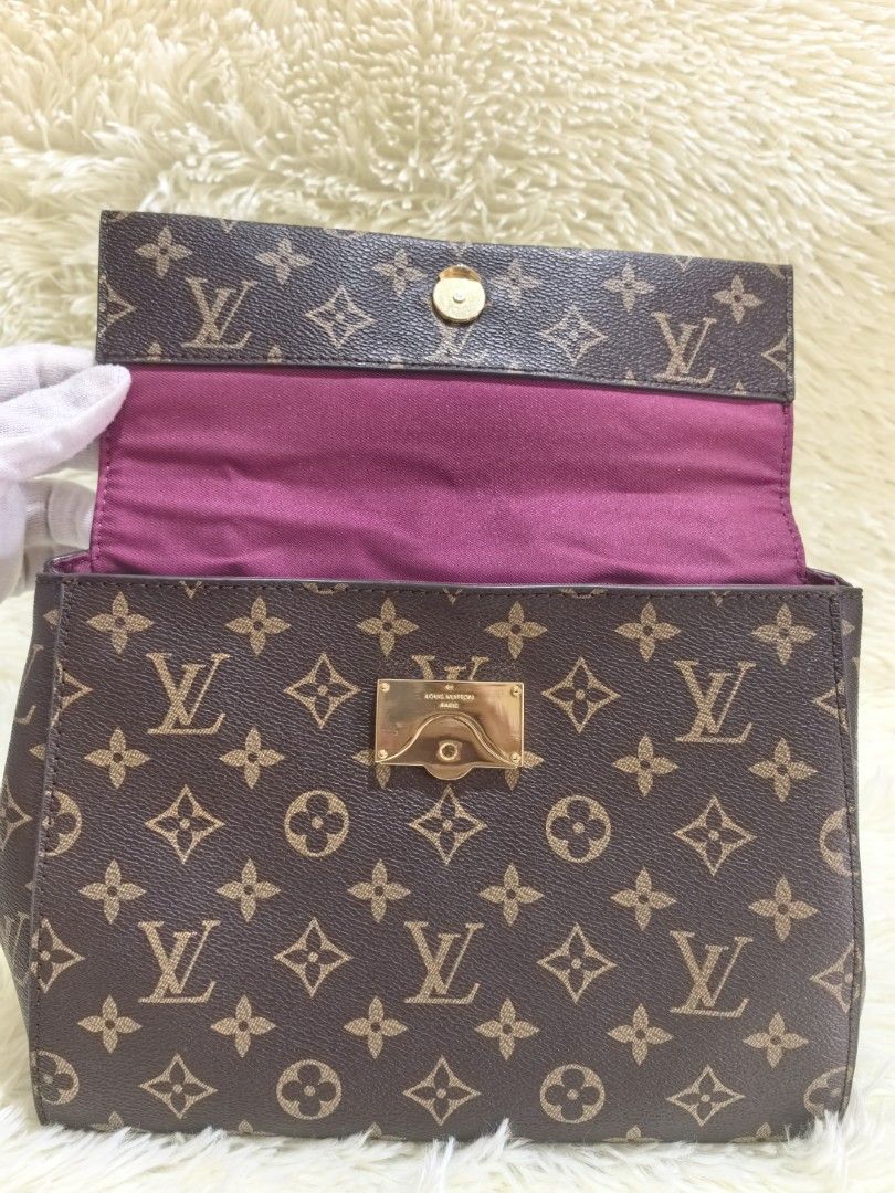 Louis Vuitton Monogram Handbag with Top Handle (Category: Luxury Bags & Wallets) located in Tacloban City. Submitted by thead.declutters (Listing ID 1470556485, Image 3). Description: - Authentic Louis Vuitton monogram canvas handbag - Classic brown and tan monogram pattern with structured shape - Elegant top handle and luxury gold-tone hardware - Secure front flap with snap closure - Vibrant pink fabric interior lining - Includes Louis Vuitton P