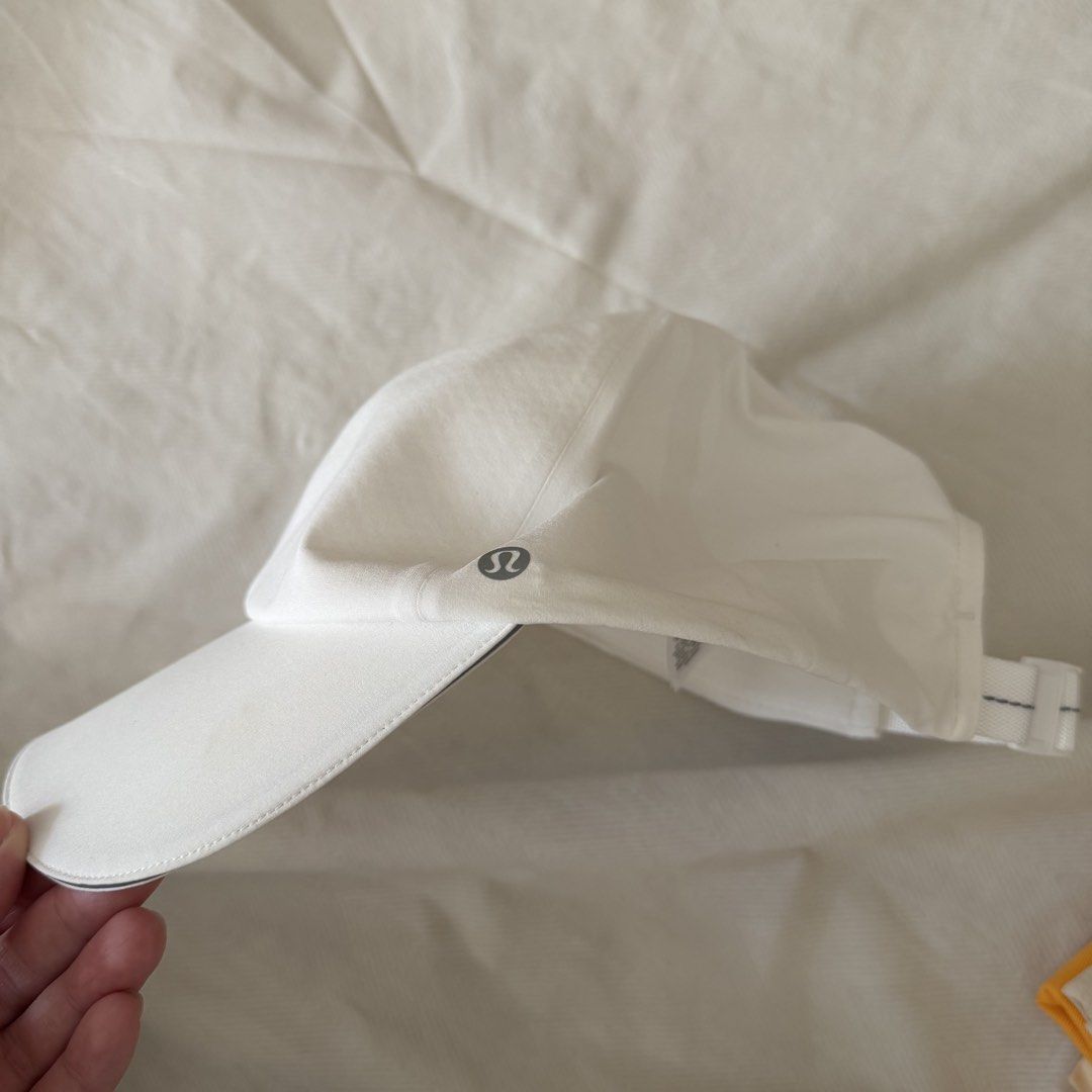 lululemon White Running Cap Hat (Category: Hats & Beanies) located in Manila. Submitted by jlssntg (Listing ID 1470429566, Image 1). Description: - Brand: Lululemon - Color: Clean white - Style: Classic curved brim with subtle reflective logo - Material: Breathable, easy to wash, and quick-drying fabric - Fit: Adjustable strap at the back for a custom fit - Ideal for: Workouts, runs, or everyday outdoor use.