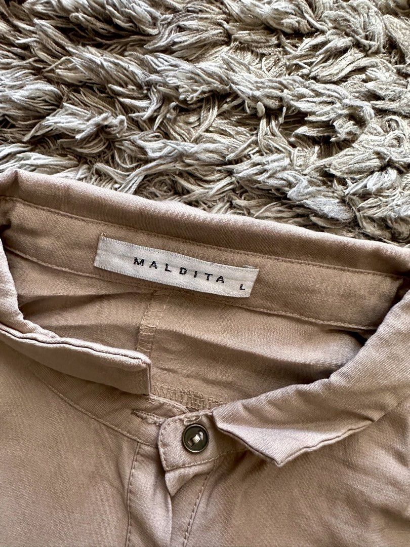 Maldita Tan Short Sleeve Button-Up Romper Size L (Category: Rompers) located in Quezon City. Submitted by k_prelovedpieces (Listing ID 1470393765, Image 2). Description: - Brand: Maldita - Size: Large (L) - Color: Versatile tan/neutral - Design: Button-up front, mandarin collar, short sleeves, and built-in waist tie belt - Pockets: Two chest pockets with button flaps - Fit: Relaxed fit shorts attached - Material: Smooth, comfortable fabric - Styl