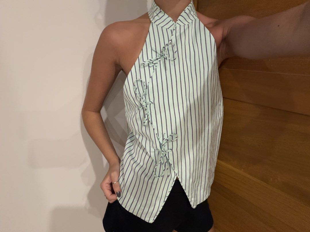 MANGO (MNG) Striped Halter Wrap Top (Category: Sleeveless) located in Muntinlupa City. Submitted by closet.natalia (Listing ID 1470478365, Image 1). Description: MANGO (MNG) Striped Halter Wrap Top ● Brand: MANGO (MNG) ● Color: Light mint green with dark stripes ● Vertical pinstripe pattern ● Halter neckline with collar detail ● Wrap-style front with adjustable side ties ● Asymmetrical pointed hem 📌 Payment: GCash, BPI bank transfer, or PayPal O