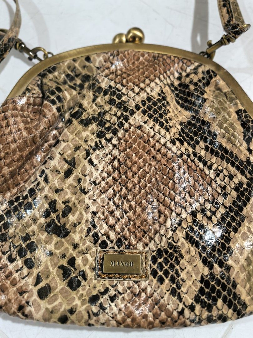 Mango Snake Print Crossbody Bag (Category: Cross-body Bags) located in Manila. Submitted by jsu2026 (Listing ID 1470501471, Image 3). Description: - Brand: Mango - Style: Crossbody bag with trendy snakeskin print - Closure: Secure kiss lock closure - Hardware: Antique brass details with front metal brand plaque - Strap: Long, adjustable, and removable with lobster clasps - Interior: Clean black fabric lining - Condition: Brand new with original t