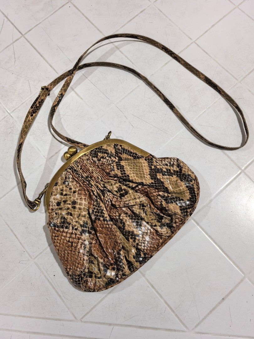 Mango Snake Print Crossbody Bag (Category: Cross-body Bags) located in Manila. Submitted by jsu2026 (Listing ID 1470501471, Image 1). Description: - Brand: Mango - Style: Crossbody bag with trendy snakeskin print - Closure: Secure kiss lock closure - Hardware: Antique brass details with front metal brand plaque - Strap: Long, adjustable, and removable with lobster clasps - Interior: Clean black fabric lining - Condition: Brand new with original t