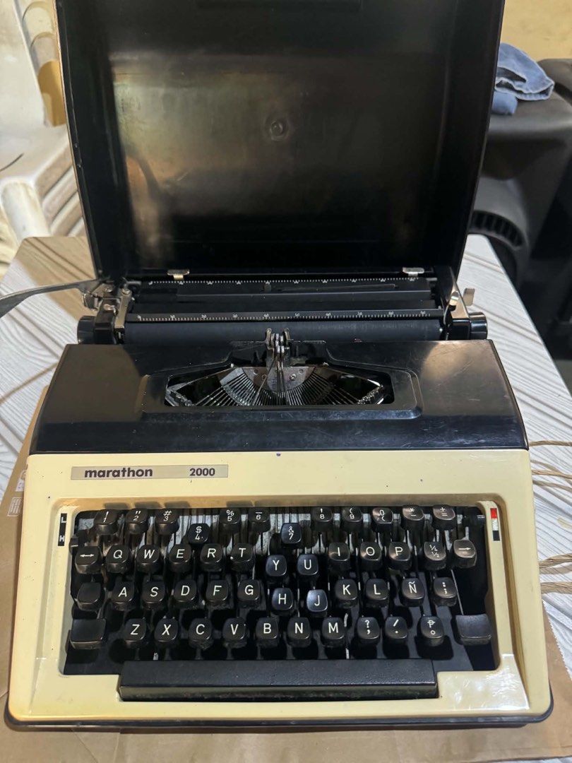 Marathon 2000 Portable Typewriter with Case (Category: Stationery & School Supplies) located in Malolos. Submitted by afsillano (Listing ID 1470432827, Image 1). Description: - Model: Marathon 2000 typewriter - Color: Classic black and cream - Layout: Standard QWERTY keyboard with full number and symbol rows - Mechanism: Standard manual typing with visible typebars - Protection: Integrated hard lid case that covers the paper table and carriage - 