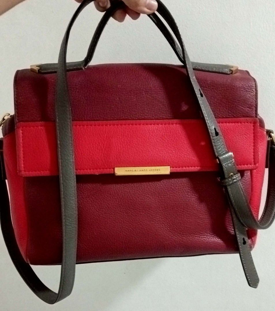 Marc by Marc Jacobs Satchel Bag (Category: Luxury Bags & Wallets) located in Siniloan. Submitted by treyyasonlineshop (Listing ID 1470492500, Image 1). Description: - SIZE: 12.5"W x 9"H x 5.5"D Authentic Marc by Marc Jacobs leather handbag in a stunning multi-shade red colorway - Structured flap closure with secure magnetic buttons and chic metal bar hardware - Versatile design featuring a top handle and a detachable crossbody strap - Spacious in