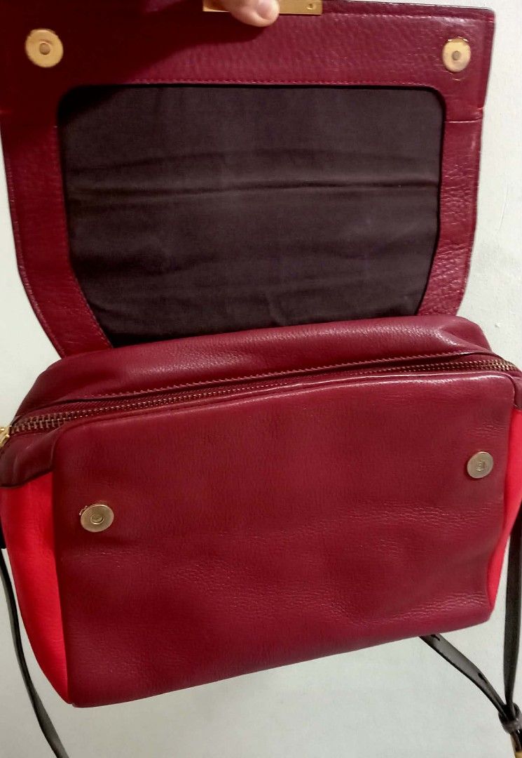 Marc by Marc Jacobs Satchel Bag (Category: Luxury Bags & Wallets) located in Siniloan. Submitted by treyyasonlineshop (Listing ID 1470492500, Image 3). Description: - SIZE: 12.5"W x 9"H x 5.5"D Authentic Marc by Marc Jacobs leather handbag in a stunning multi-shade red colorway - Structured flap closure with secure magnetic buttons and chic metal bar hardware - Versatile design featuring a top handle and a detachable crossbody strap - Spacious in