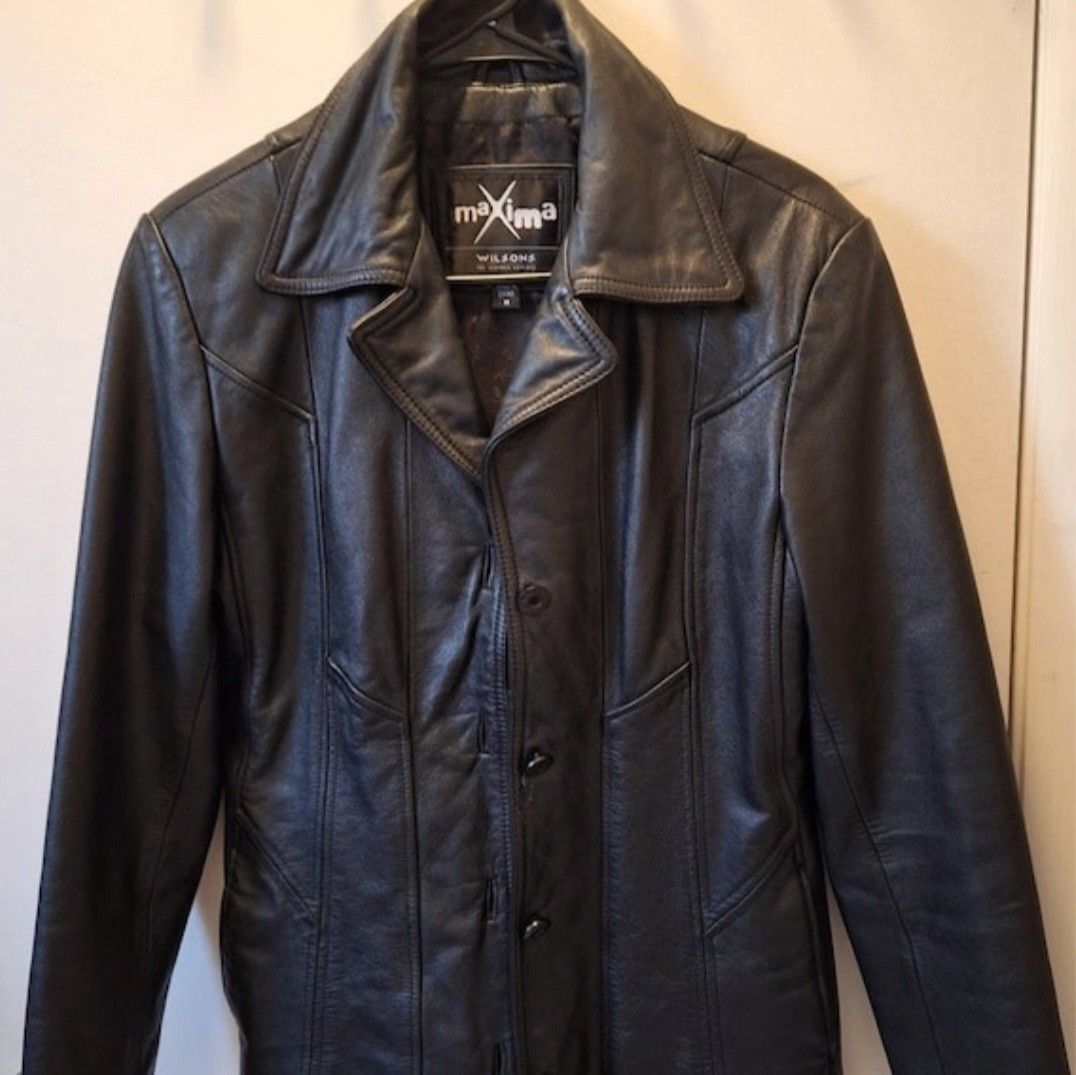 Maxima Wilsons Leather Jacket (Category: Coats, Jackets and Outerwear) located in Manila. Submitted by fiercehorse-60ca (Listing ID 1470484987, Image 2). Description: - Brand: Maxima Wilsons - Material: 100% Genuine Leather - Color: Classic Black - Size: Medium (tag attached at inner collar) - Closure: Button-up front with lapel collar - Design: Panelled stitching details on front and back - Condition: Excellent pre-loved condition - Perfect for 