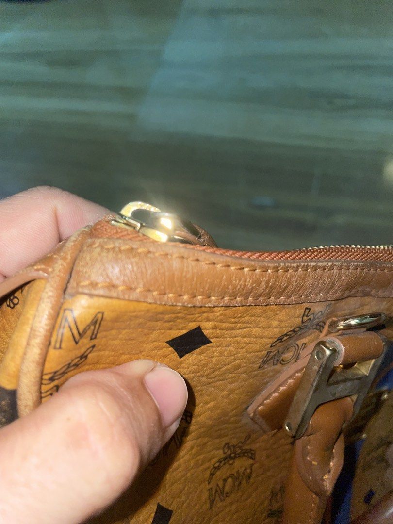 MCM Cognac Visetos Monogram Stripe Boston Handbag (Category: Luxury Bags & Wallets) located in Manila. Submitted by clementdav22513 (Listing ID 1470448994, Image 3). Description: - Authentic MCM Boston Bag in signature cognac monogram print - Eye-catching blue and orange vertical stripes on the front - Includes a playful, detachable bone-shaped leather charm - Features dual top handles, secure top zip closure, and gold-tone hardware - Front seria