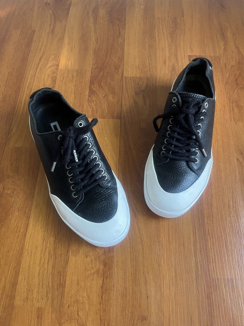 McQ Alexander McQueen Black Tumbled Leather Platform Sneakers (Category: Sneakers) located in Lipa City. Submitted by alexcollectionco (Listing ID 1470491196, Image 2). Description: Bold luxury low-top sneakers from McQ by Alexander McQueen. Crafted from premium black tumbled pebbled leather featuring a contrasting white toe cap, unique rear heel-lacing/grommet detailing, and thick rubber platform soles with debossed McQ lettering. A striking ava