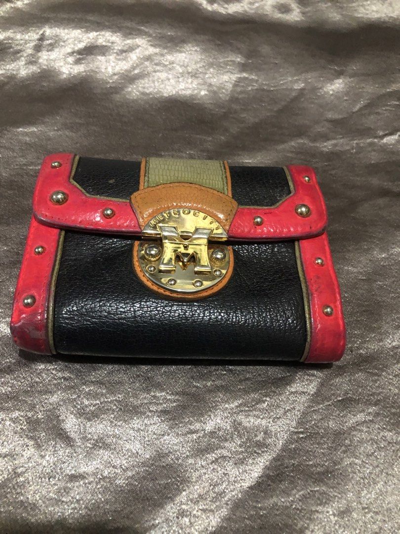Metrocity multi-color leather folded wallet with gold hardware (Category: Wallets & Card holders) located in Valenzuela. Submitted by nixs2722 (Listing ID 1470537191, Image 2). Description: - Brand: Metrocity - Material: Genuine leather in black, pink, orange, and green - Hardware: Gold-tone lock closure on front flap - Interior: Multiple card slots, clear ID window, and zipped coin pouch - Condition: Noticeable edge wear and scuffing from regula