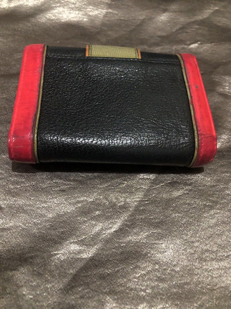 Metrocity multi-color leather folded wallet with gold hardware (Category: Wallets & Card holders) located in Valenzuela. Submitted by nixs2722 (Listing ID 1470537191, Image 3). Description: - Brand: Metrocity - Material: Genuine leather in black, pink, orange, and green - Hardware: Gold-tone lock closure on front flap - Interior: Multiple card slots, clear ID window, and zipped coin pouch - Condition: Noticeable edge wear and scuffing from regula