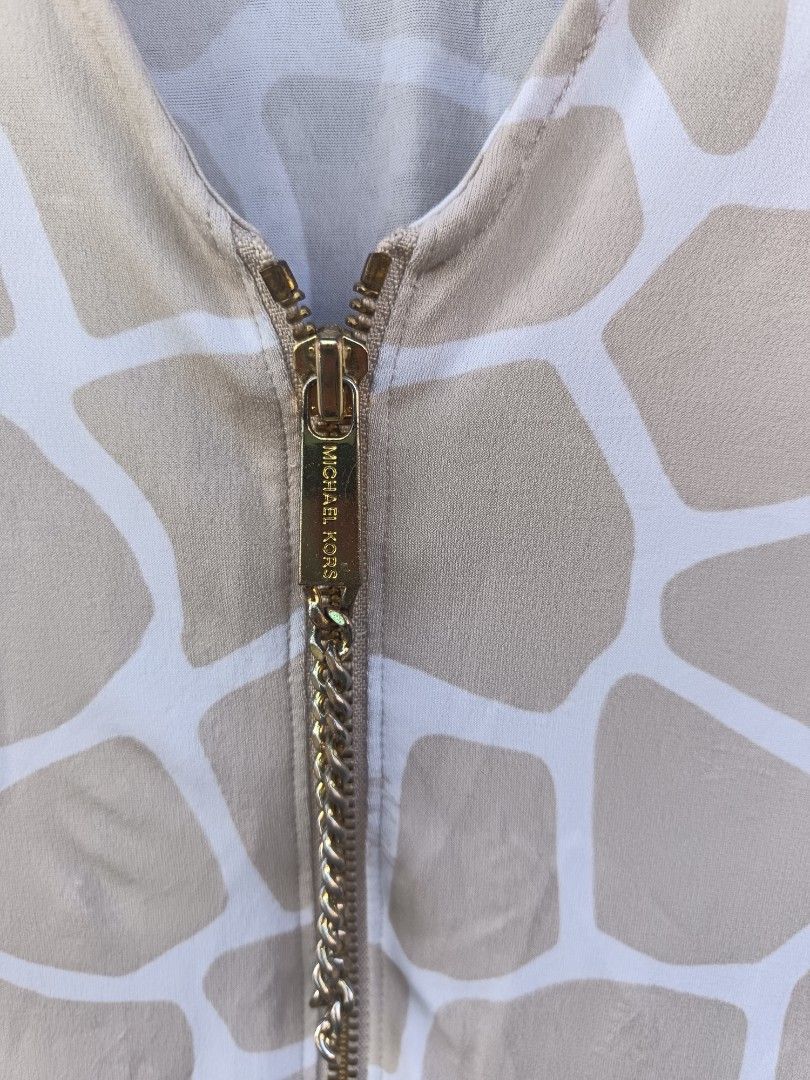 Michael kors (Category: Blouses) located in Aroroy. Submitted by vin2za06 (Listing ID 1470349896, Image 3). Description: The image shows a beige and cream giraffe-print blouse from Michael Kors featuring a V-neckline with a gold-toned front zipper.