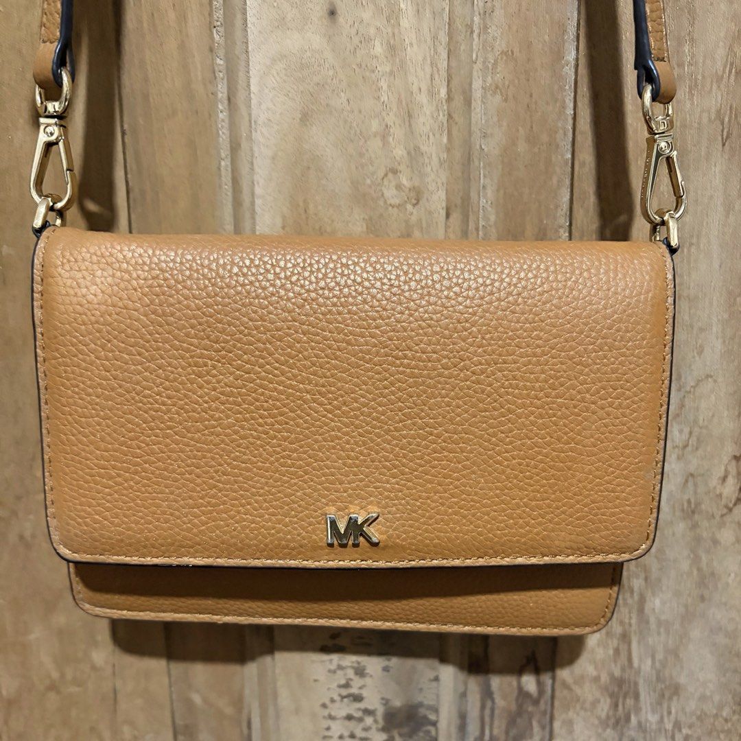 Michael Kors Brown Leather Crossbody Bag (Category: Cross-body Bags) located in Quezon City. Submitted by mayangski77 (Listing ID 1470360493, Image 1). Description: Tan pebble leather Michael Kors crossbody bag with gold tone hardware. Flap front design featuring the MK logo. Inside has built-in card slots and a zip pocket. Back slip pocket for easy phone access. Adjustable and detachable strap included. Compact size, great for carrying essential
