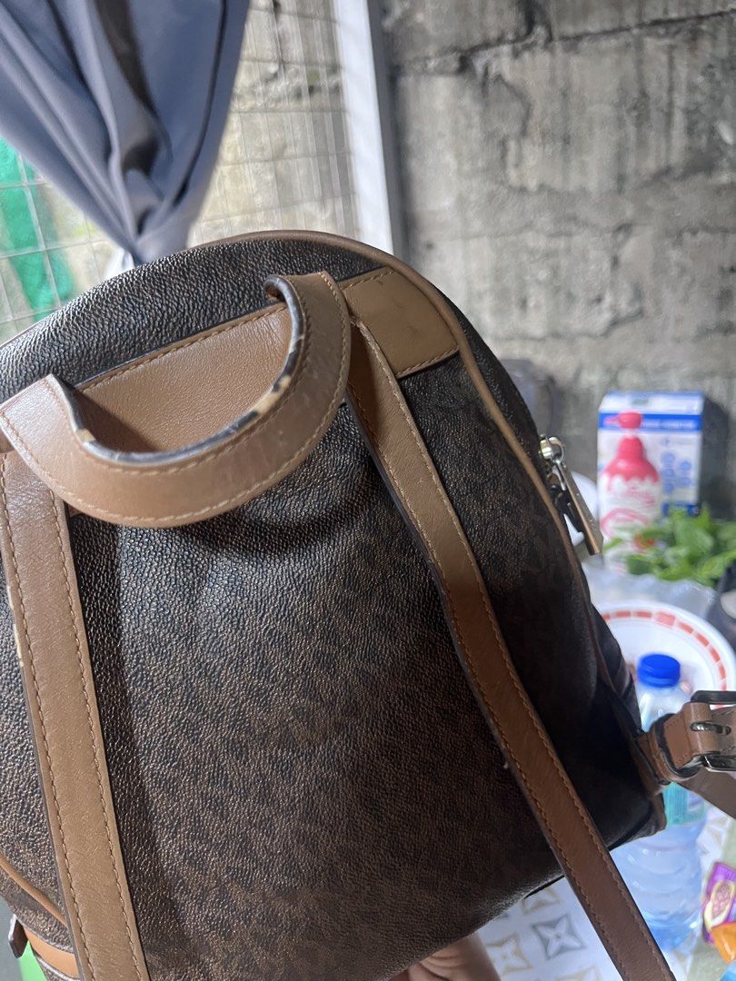 Michael Kors Brown Signature Logo Leather Backpack (Category: Backpacks) located in Manila. Submitted by madecuratedwithlove11 (Listing ID 1470422008, Image 3). Description: - Authentic Michael Kors backpack - Issue: Rubber lining, bottom part rubs, inside merong stitch - Classic brown signature monogram print with tan leather trim - Gold-tone hardware and front zippered pocket with logo lettering - Adjustable straps and top carry handle - Fabric