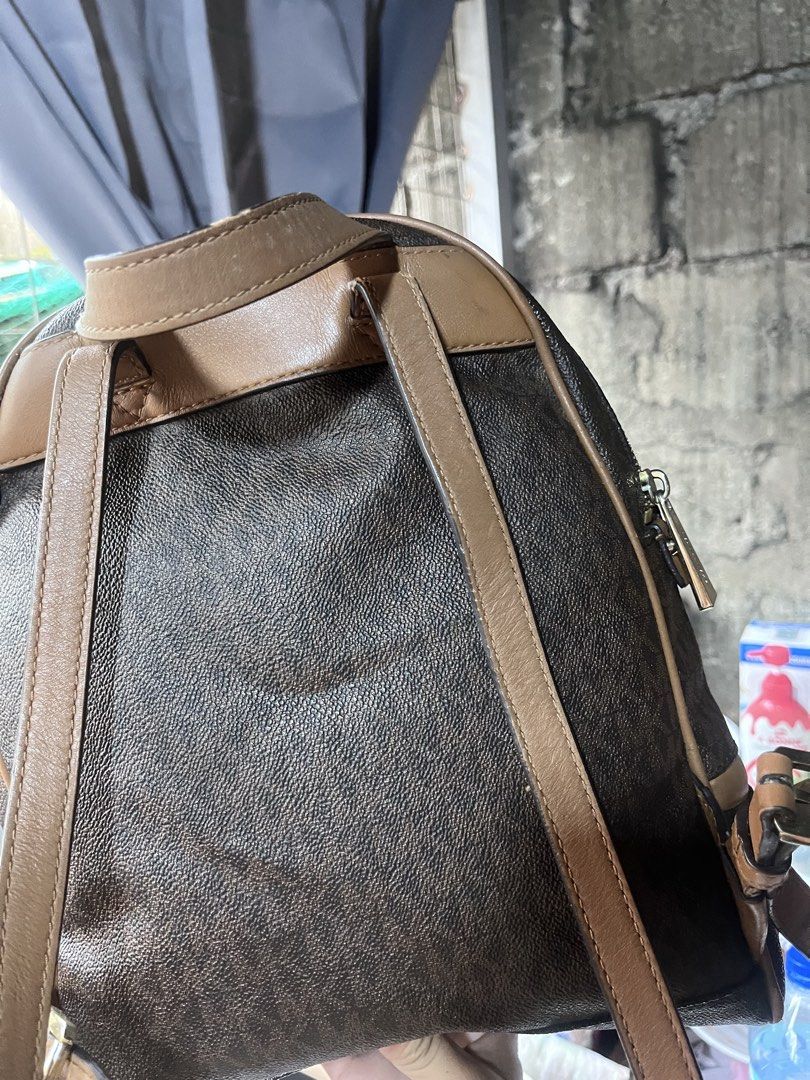 Michael Kors Brown Signature Logo Leather Backpack (Category: Backpacks) located in Manila. Submitted by madecuratedwithlove11 (Listing ID 1470422008, Image 2). Description: - Authentic Michael Kors backpack - Issue: Rubber lining, bottom part rubs, inside merong stitch - Classic brown signature monogram print with tan leather trim - Gold-tone hardware and front zippered pocket with logo lettering - Adjustable straps and top carry handle - Fabric