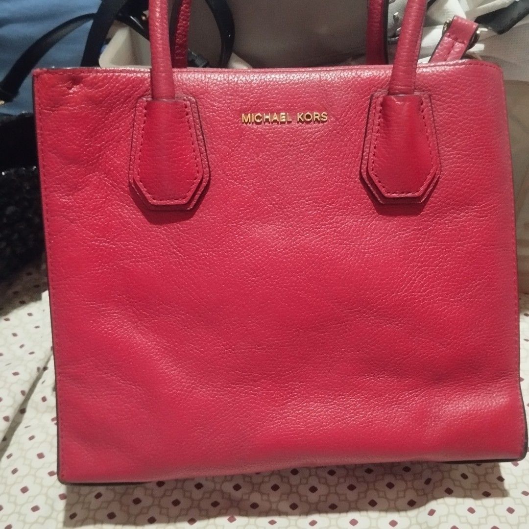 Michael Kors Red Leather Tote Bag (Category: Tote Bags) located in Manila. Submitted by lene48 (Listing ID 1470503836, Image 2). Description: - Brand: Michael Kors - Color: Bright red - Material: Genuine pebbled leather - Hardware: Gold-tone - Handles: Double top handles - Interior: Fabric lining with zippered center compartment and brand plaque - Base: Protective metal feet.