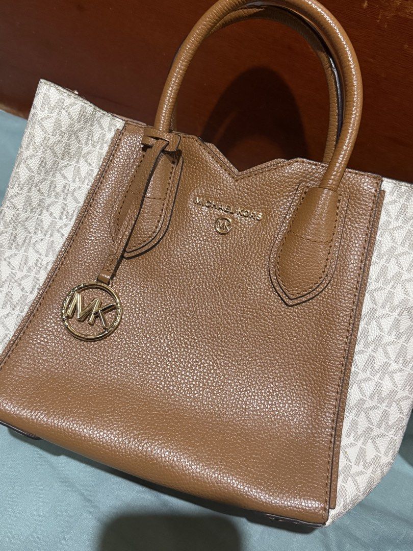 Michael Kors Two-Tone Tote Bag (Category: Tote Bags) located in Manila. Submitted by errgasm21 (Listing ID 1470371727, Image 1). Description: - Brand: Michael Kors - Style: Leather Tote Bag - Color/Design: Brown center panel with white monogram sides - Hardware: Gold-tone - Details: Dual top handles, signature MK hanging charm, embossed logo lettering - Condition: Clean, textured finish - Mode of Payment: BPI, BDO, Gcash - Shipping: Via J&T or LB