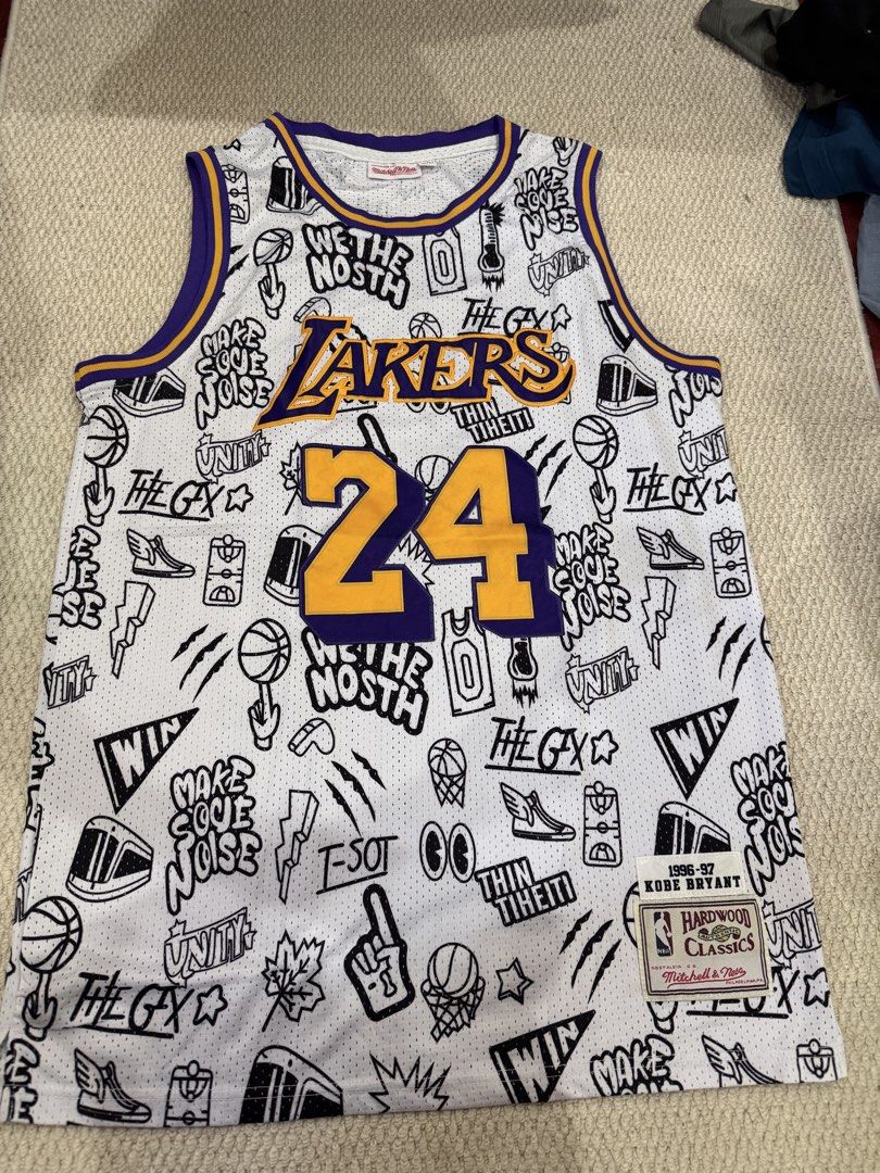 Mitchell & Ness Kobe Bryant 1996-97 Lakers Jersey Size 48 (Category: Activewear) located in Valenzuela. Submitted by crabncorn (Listing ID 1470360455, Image 1). Description: - Brand: Mitchell & Ness Hardwood Classics - Player/Era: Kobe Bryant 1996-97 Season - Design: White base with all-over black and white doodle graphics, purple and yellow collar/armhole trim - Details: Heat-pressed player name and number 24 in yellow with purple trim - Sizing: