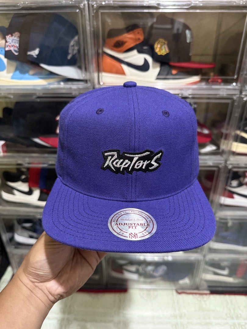 (Wool) Mitchell & Ness Toronto Raptors Snapback Cap Purple (Category: Caps & Hats) located in Manila. Submitted by batoy8814895 (Listing ID 1470434279, Image 1). Description: - Brand: Mitchell & Ness - Team: Toronto Raptors (Throwback Purple Colorway) - Logos: Classic script on front, iconic dinosaur on the side - Fit: Adjustable plastic snap closure - Brim: Flat brim with original authenticity sticker attached - Condition: Brand new / Excellent.
