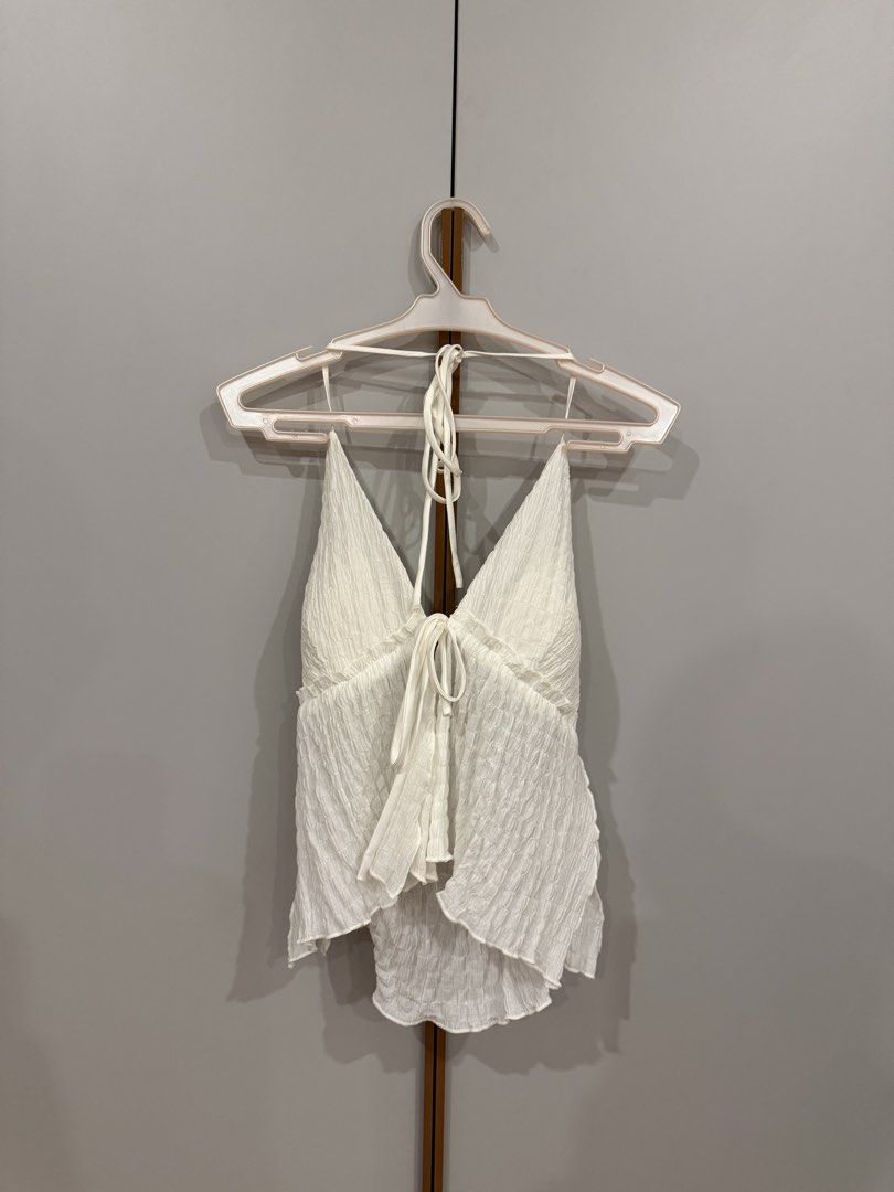 MITR White Textured Halter Tie-Front Top (Category: Sleeveless) located in Muntinlupa City. Submitted by closet.natalia (Listing ID 1470479344, Image 3). Description: MITR White Textured Halter Tie-Front Top ● Brand: MITR ● Size: S (US 4 / UK 8 / EU 36) ● Color: White / Ivory ● Deep V-neckline with halter neck tie ● Adjustable tie-front detailing ● Open-back design ● Lightweight textured fabric ● Flowy, ruffled hem 📌 Payment: GCash, BPI bank tra