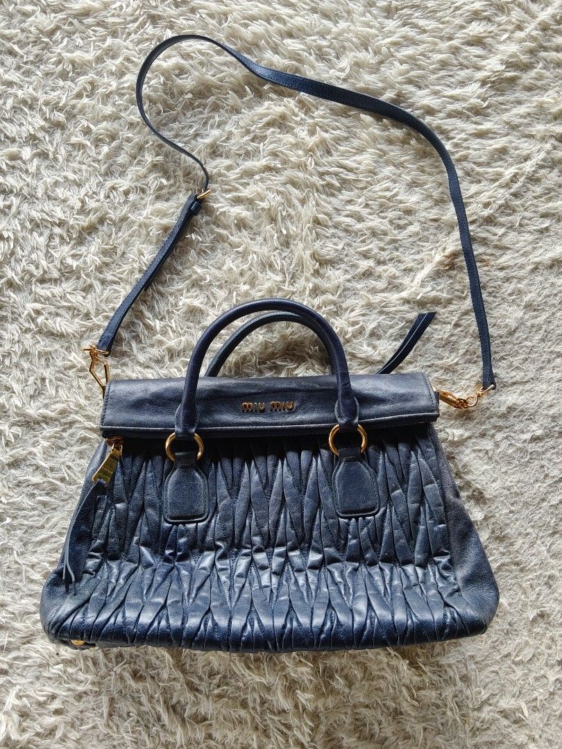 MIU MIU MATELASSE LEATHER SATCHEL (Category: Luxury Bags & Wallets) located in Valencia. Submitted by coolwolf_27a64f (Listing ID 1470366800, Image 1). Description: Authentic Miu Miu Matelassé Leather Satchel Bag in Navy Blue 🔵 ✨ Features the iconic gathered matelassé quilting, dual structured top handles, and a detachable crossbody strap for versatile styling. Complemented by striking gold-tone hardware and the classic front logo lettering. Per