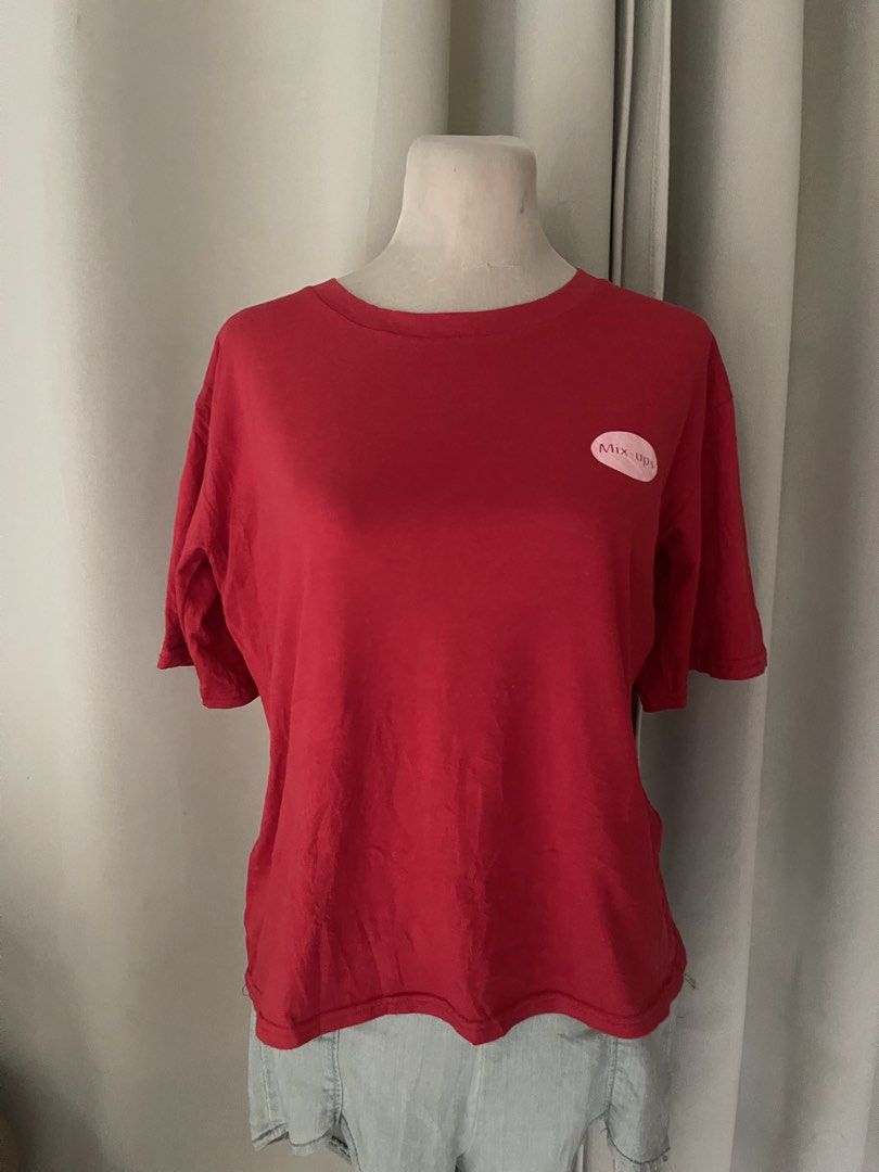 M&M's Mix-Ups Surrounded By Nuts Red Tee (Category: Shirts) located in Cainta. Submitted by zlove111 (Listing ID 1470456428, Image 3). Description: - Color: Bright red - Fit: Relaxed fit with a classic crew neck - Front Detail: Small pink Mix-ups oval logo on the left chest - Back Detail: Large M&M characters graphic with 'Surrounded by Nuts' text - Style: Fun vintage candy merch up to large 21".