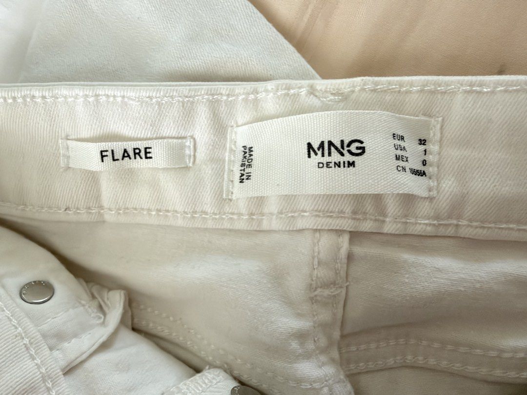 MNG Denim Flare White Pants (Category: Jeans) located in Manila. Submitted by itsarah (Listing ID 1470387998, Image 2). Description: White flare jeans from MNG Denim. Features a button-fly closure, vertical seam details, and a fitted thigh with a flared hem. Size: EUR 32 / USA 1 / MEX 0. Made in Pakistan. Clean and stylish!.