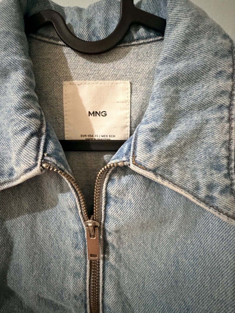 Mango Light Wash Denim Zip Jacket (Category: Coats, Jackets and Outerwear) located in Quezon City. Submitted by bela_goodfinds (Listing ID 1470413869, Image 2). Description: - Brand/Model: MNG cropped denim jacket - Color/Wash: Light wash blue with a great vintage-style finish - Size: XS (Made in Pakistan) - Closure & Details: Full front zipper with collar - Fit: Elasticized waistband and cuffs for a gathered look - Pockets: Two front slash pocke