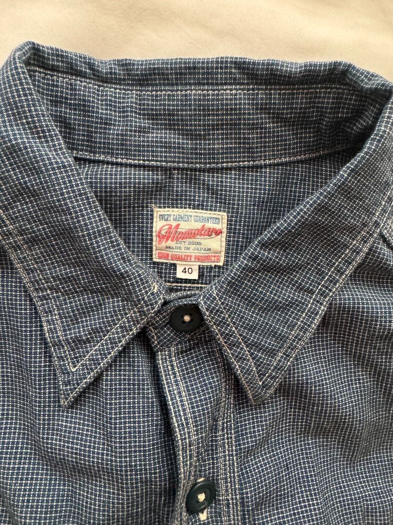 Momotaro Jeans Long sleeve button down shirt indigo patterned (Category: Formal Shirts) located in Cebu City. Submitted by _t.rix (Listing ID 1470366008, Image 3). Description: - Color: Indigo blue - Design: Subtle all-over textured pattern with structured collar - Pockets: Two front chest pockets with button flaps - Details: Dark buttons on center placket and sleeve cuffs - Hem: Standard shirt hem with clean stitching throughout Made in Japan.