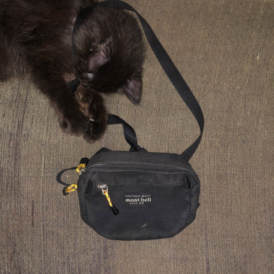 Mont-bell small sling bag (Category: Cross-body Bags) located in Mandaluyong City. Submitted by philbert420 (Listing ID 1470541483, Image 1). Description: - Brand: Mont-bell - Color: Classic black with yellow zipper pulls - Features: Adjustable shoulder strap and front zipped pocket for small essentials - Condition: Excellent - Note: Cat is strictly not included!.