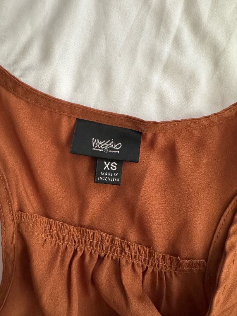 Mossimo Rust Orange Racerback Tank Top Size XS (Category: Sleeveless) located in Cebu City. Submitted by _t.rix (Listing ID 1470373708, Image 2). Description: - Brand: Mossimo - Size: XS - Color: Rust orange - Material: Lightweight, flowy fabric (Made in Indonesia) - Design: Racerback with gathered pleated neckline and curved hem - Condition: Great basic piece for layering or wearing solo.