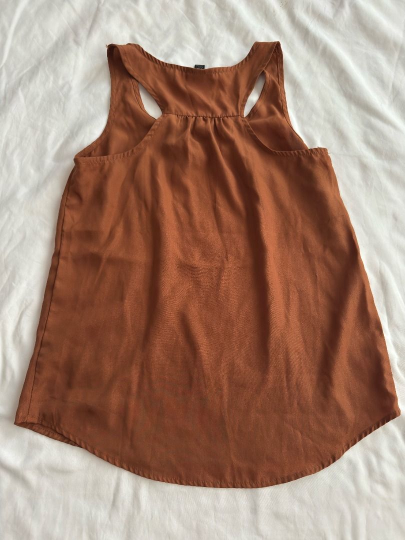 Mossimo Rust Orange Racerback Tank Top Size XS (Category: Sleeveless) located in Cebu City. Submitted by _t.rix (Listing ID 1470373708, Image 3). Description: - Brand: Mossimo - Size: XS - Color: Rust orange - Material: Lightweight, flowy fabric (Made in Indonesia) - Design: Racerback with gathered pleated neckline and curved hem - Condition: Great basic piece for layering or wearing solo.