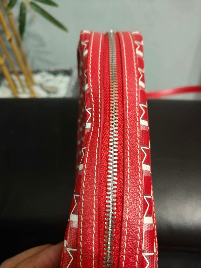 Moynat Red Patterned Crossbody Bag (Category: Luxury Bags & Wallets) located in Bay. Submitted by silverhorse-59c851 (Listing ID 1470557264, Image 2). Description: - Brand: Moynat Crossbody Bag - Color/Pattern: Red with white and pink signature monogram - Closure: Zip-top main compartment with exterior flap pocket - Strap: Red leather shoulder strap with silver-tone hardware - Interior: Cream fabric lining with a convenient slip pocket - Style: C