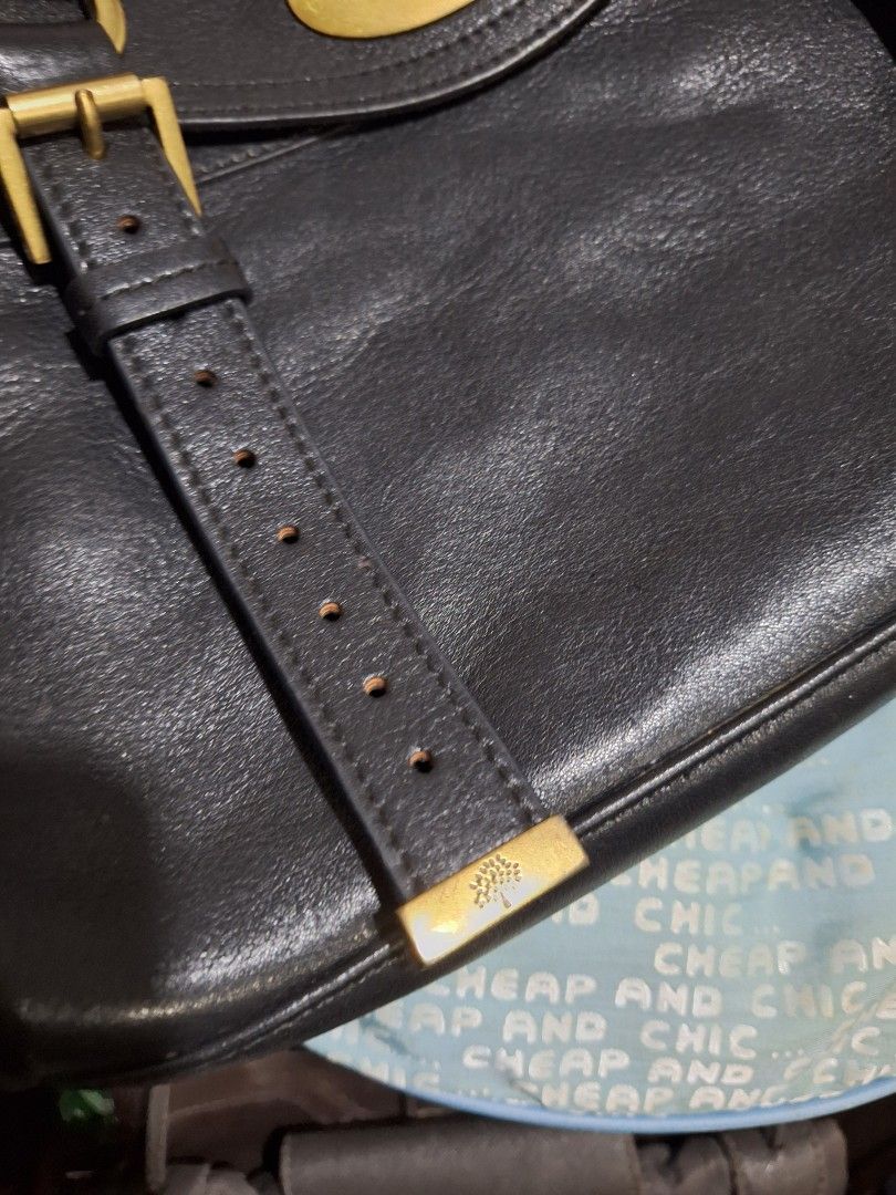 Mulberry Black Leather Shoulder Bag (Category: Luxury Bags & Wallets) located in Quezon City. Submitted by cloudymay (Listing ID 1470552032, Image 3). Description: Authentic Black textured leather handbag by Mulberry. Brass hardware including dual buckle straps across the front and central turn-lock closure. Braided top handle plus shoulder strap. Olive green fabric lining featuring Mulberry tree motif throughout. Interior zip pocket and slip com