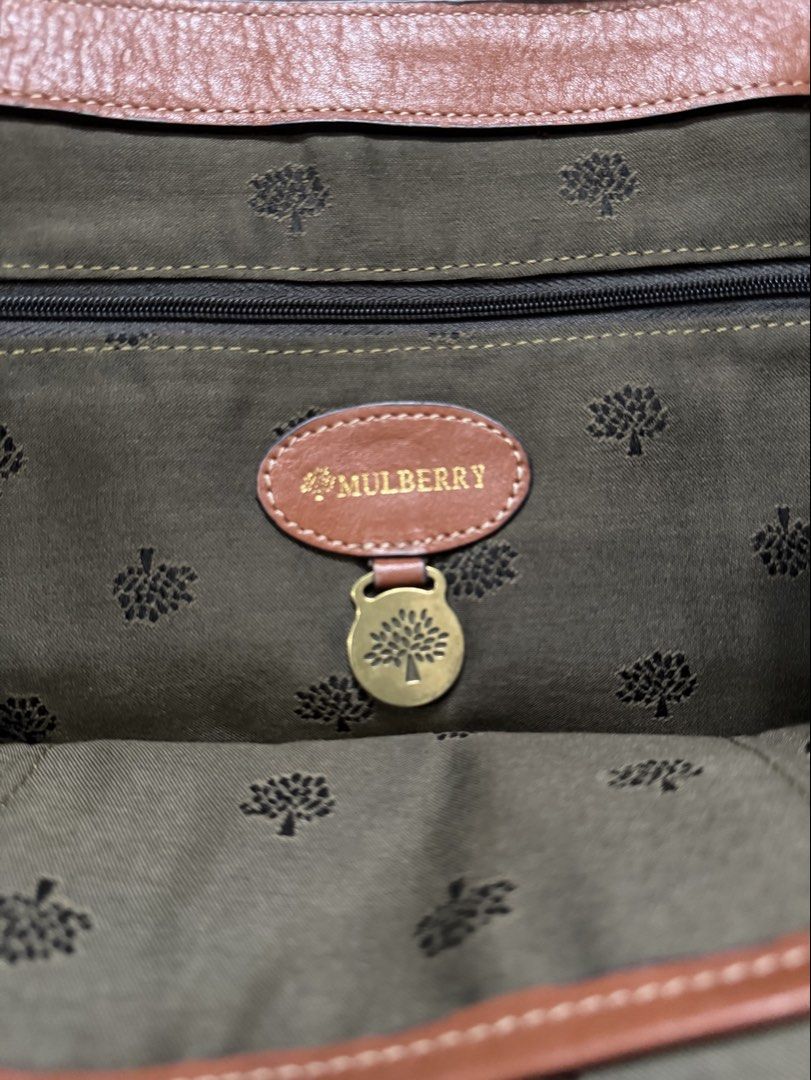 Mulberry Brown Leather Satchel Handbag (Category: Luxury Bags & Wallets) located in Quezon City. Submitted by candyclosetph (Listing ID 1470455697, Image 3). Description: - Authentic Mulberry leather satchel in a rich brown shade - Classic postman lock closure with iconic tree logo and brass-tone hardware - Dual buckle strap front detail with a stylish braided top handle - Olive green fabric interior lining featuring the Mulberry logo pattern wit