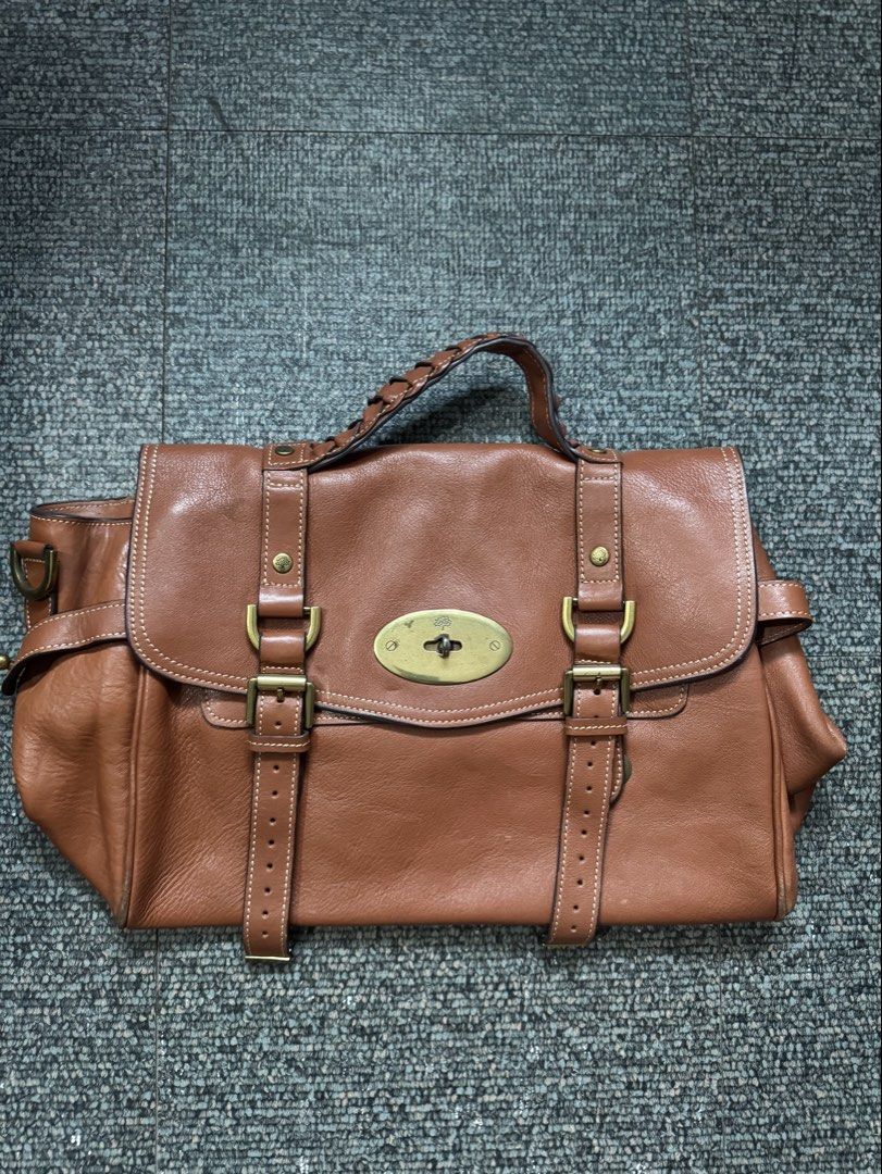 Mulberry Brown Leather Satchel Handbag (Category: Luxury Bags & Wallets) located in Quezon City. Submitted by candyclosetph (Listing ID 1470455697, Image 1). Description: - Authentic Mulberry leather satchel in a rich brown shade - Classic postman lock closure with iconic tree logo and brass-tone hardware - Dual buckle strap front detail with a stylish braided top handle - Olive green fabric interior lining featuring the Mulberry logo pattern wit