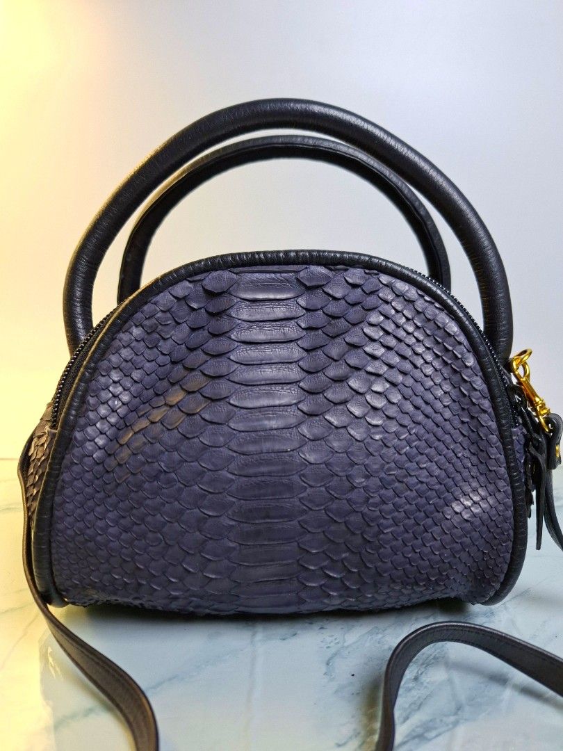 Navy Python Skin Leather Handbag with Strap (Category: Luxury Bags & Wallets) located in Pasay City. Submitted by onick_79 (Listing ID 1470404003, Image 1). Description: - Navy blue python skin texture with smooth black leather trim - Elegant gold-tone hardware and detachable shoulder strap - Dual top zipper closure with secure black pulls - Compact dome shape that stands upright on its own - Versatile design, ideal for both everyday wear and spe