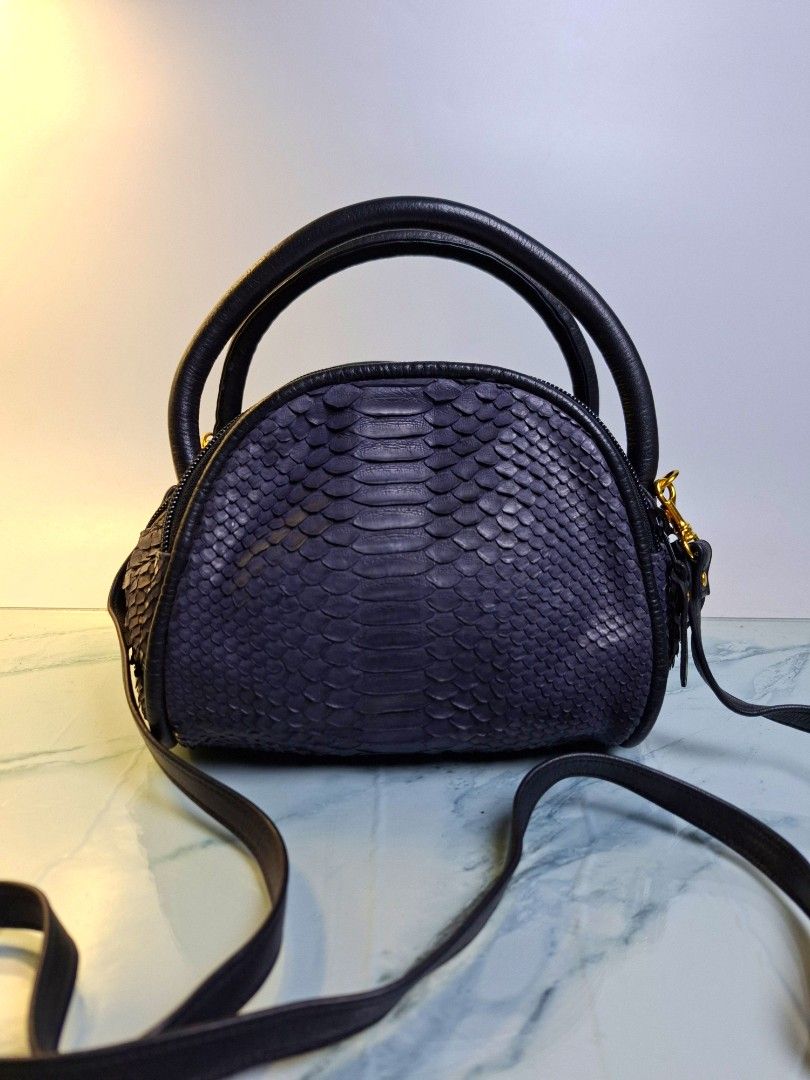 Navy Python Skin Leather Handbag with Strap (Category: Luxury Bags & Wallets) located in Pasay City. Submitted by onick_79 (Listing ID 1470404003, Image 3). Description: - Navy blue python skin texture with smooth black leather trim - Elegant gold-tone hardware and detachable shoulder strap - Dual top zipper closure with secure black pulls - Compact dome shape that stands upright on its own - Versatile design, ideal for both everyday wear and spe